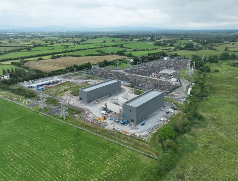 Luchtfoto van industriële krachtcentrale in groen landelijk landschap.