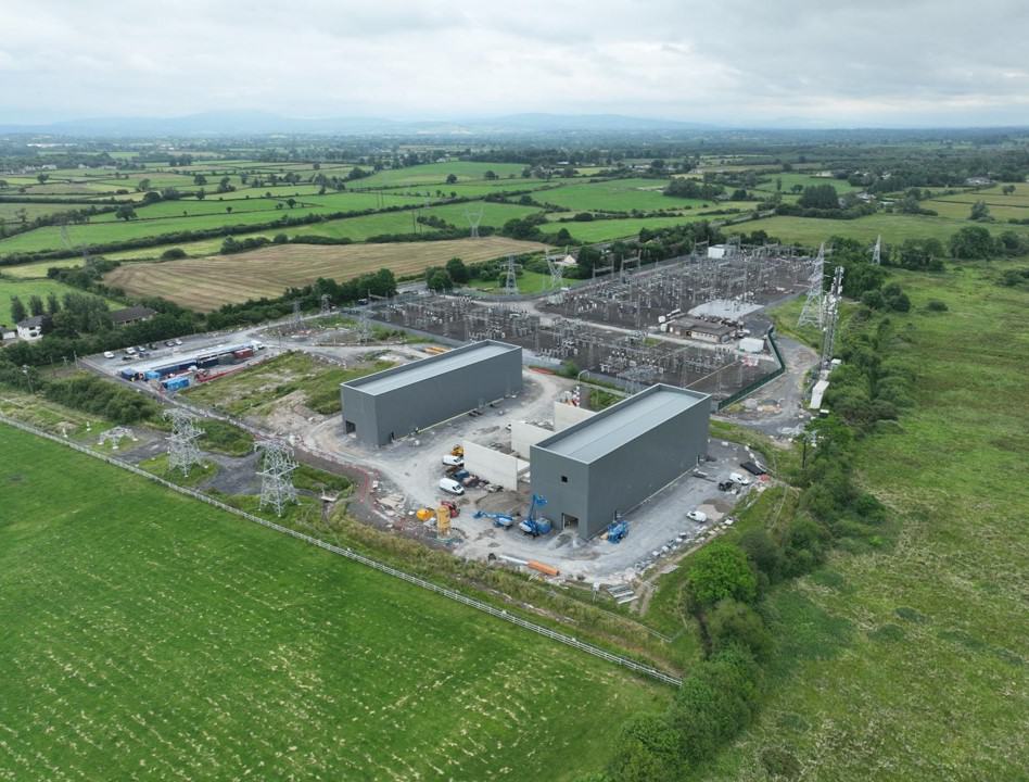 Aerial view of industrial power station in green rural landscape.