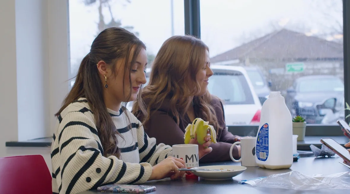 Dos mujeres desayunan juntas en el interior de una casa.